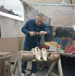 831115 Afbeelding van een klompenmaker tijdens een demonstratie oude ambachten op de jaarmarkt in Cothen die werd ...
